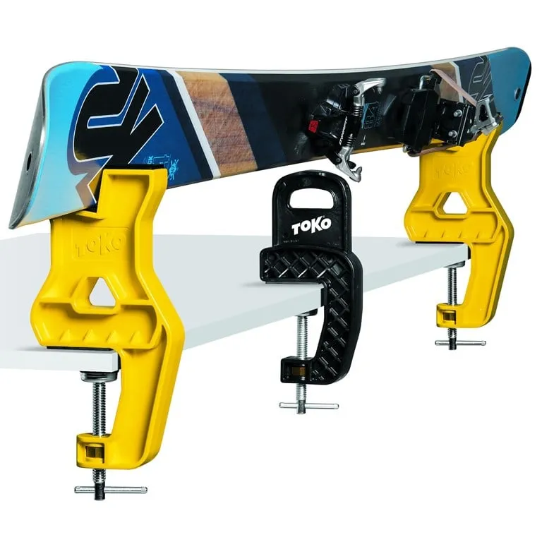 Ski in gelbem und schwarzem Toko Express BC Vise auf einer weißen Oberfläche.