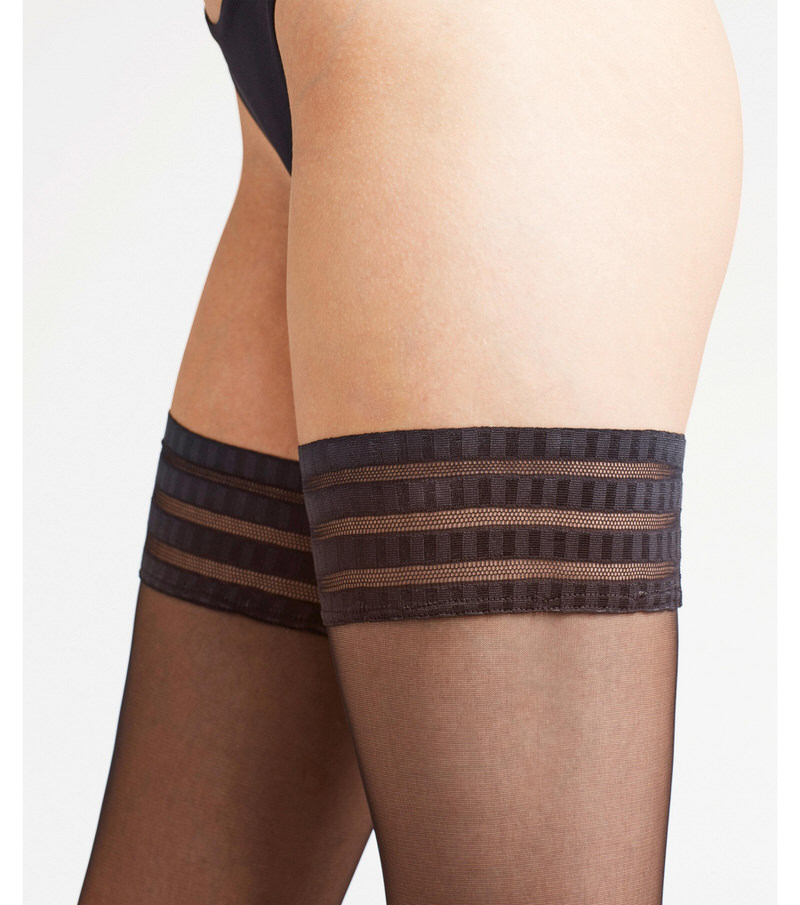 Bein mit schwarzem, mattem Stay-Up mit dekorativer Spitze und Silikonband.