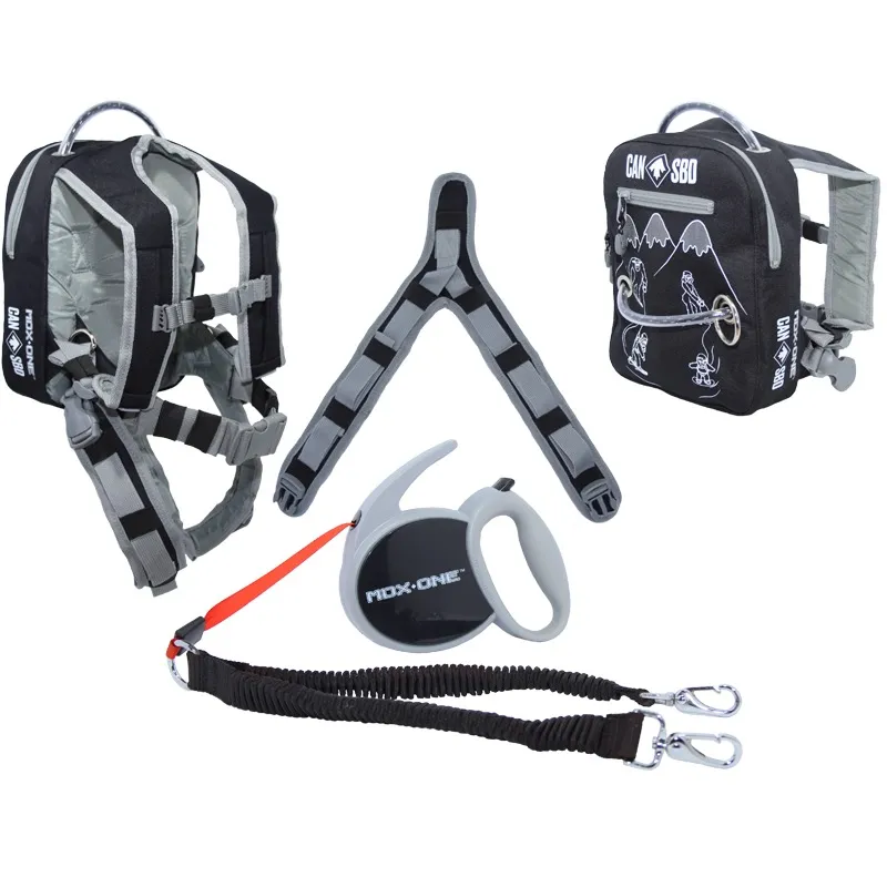 Snowboard learning aid set for kids in black/gray: Kids' harness with backpack function, adjustable straps, and handle; length-adjustable leash with carabiner; separate hand reel for pulling in for more control.