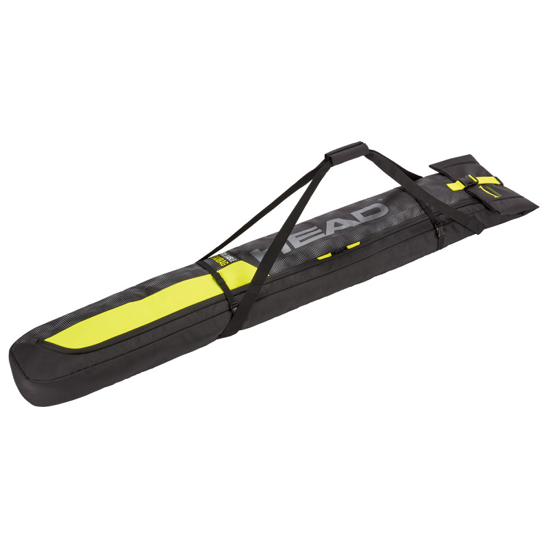 Black Head double ski bag with yellow accents and angled carrying straps.