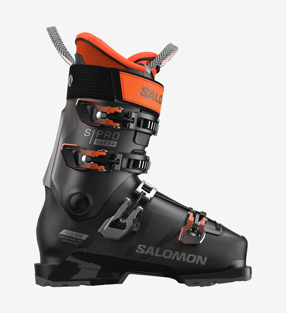 Schwarzer Salomon S/PRO Supra 110 Skischuh, seitliche Ansicht, mit orangefarbenen Akzenten und Schnallen.