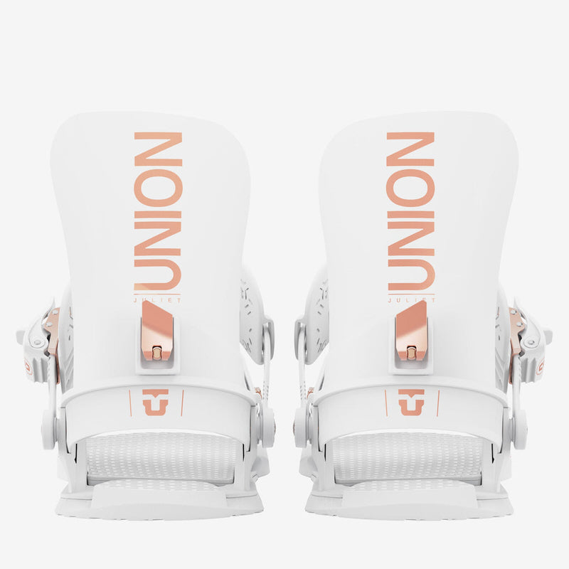 Union Juliet Snowboardbindungen Zwei weiße Union Juliet Snowboardbindungen von hinten, mit kupferfarbenen Akzenten und der Aufschrift "Union".