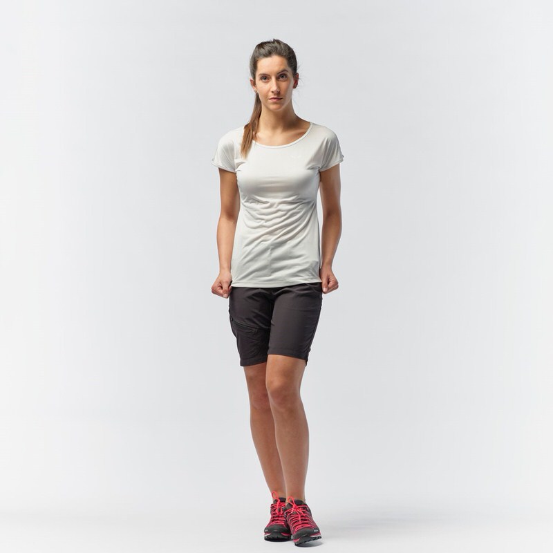Eine Frau mit einem weißen Salewa Puez Melange Dry'Ton T-Shirt und Shorts steht vor einem weißen Hintergrund.
