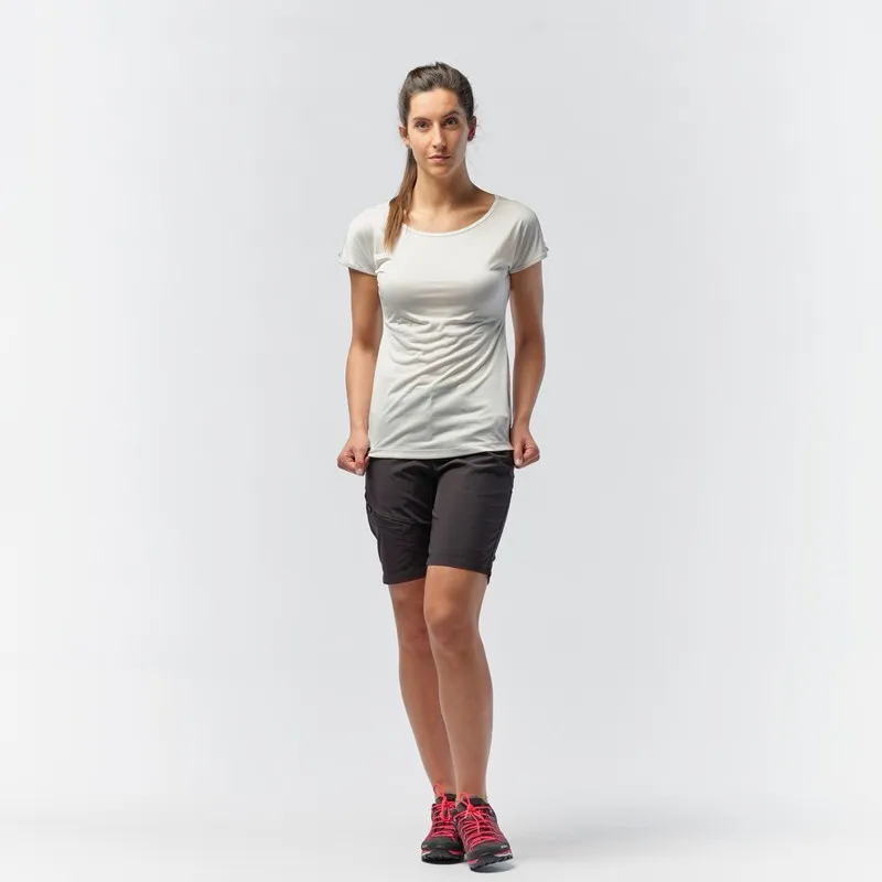 Eine Frau mit einem weißen Salewa Puez Melange Dry'Ton T-Shirt und Shorts steht vor einem weißen Hintergrund.