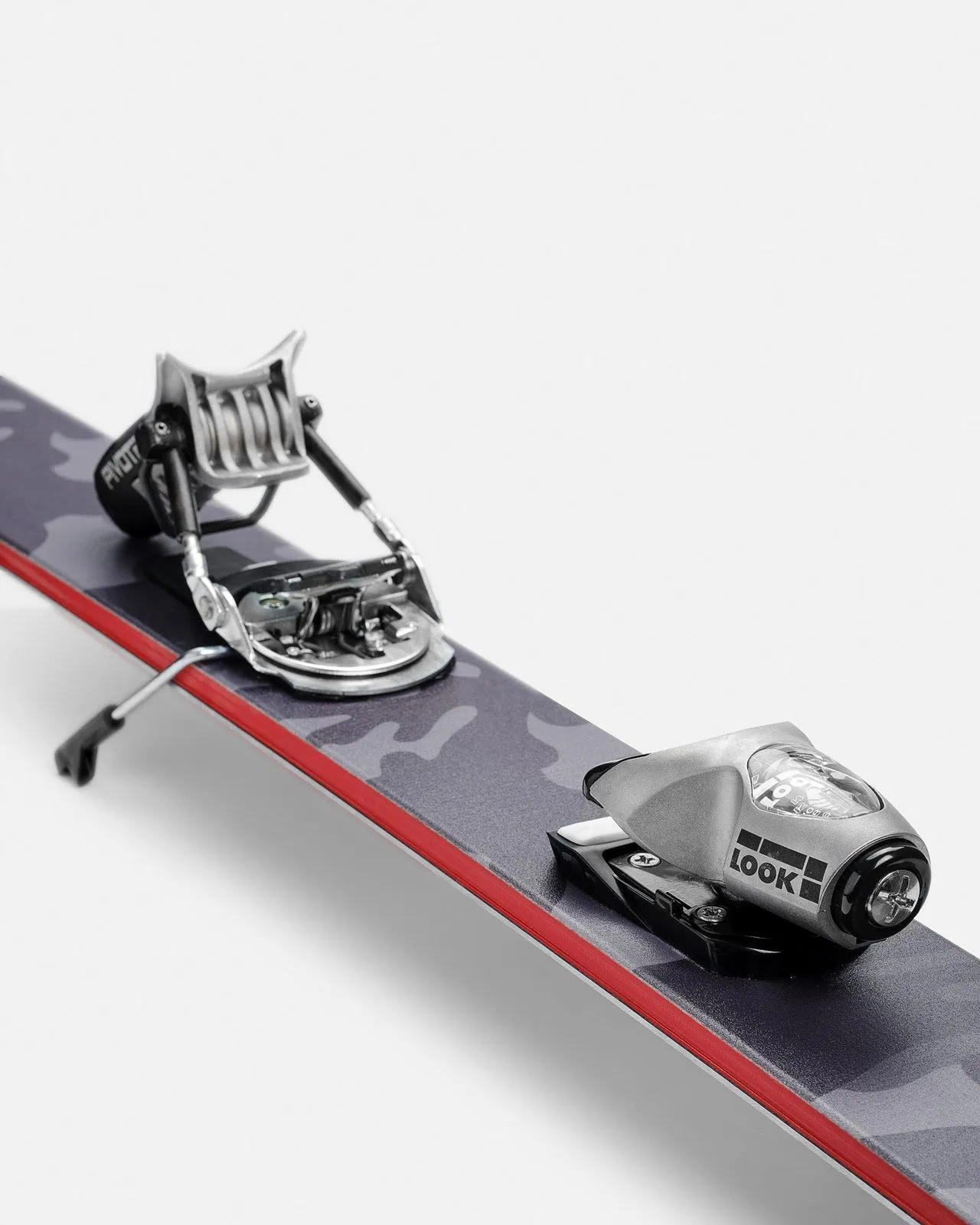 Gros plan sur le ski W3 Van Deer avec la fixation Look Pivot montée sur un motif de camouflage gris.