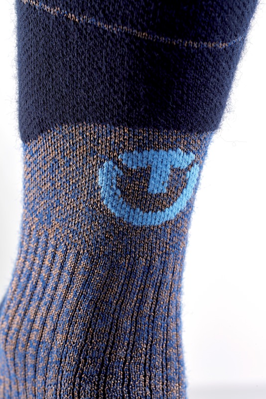 Detailaufnahme einer Therm-ic Ski Merino Reflector Herren Skisocke, mit blauem Logo auf blau-braun meliertem Untergrund.
