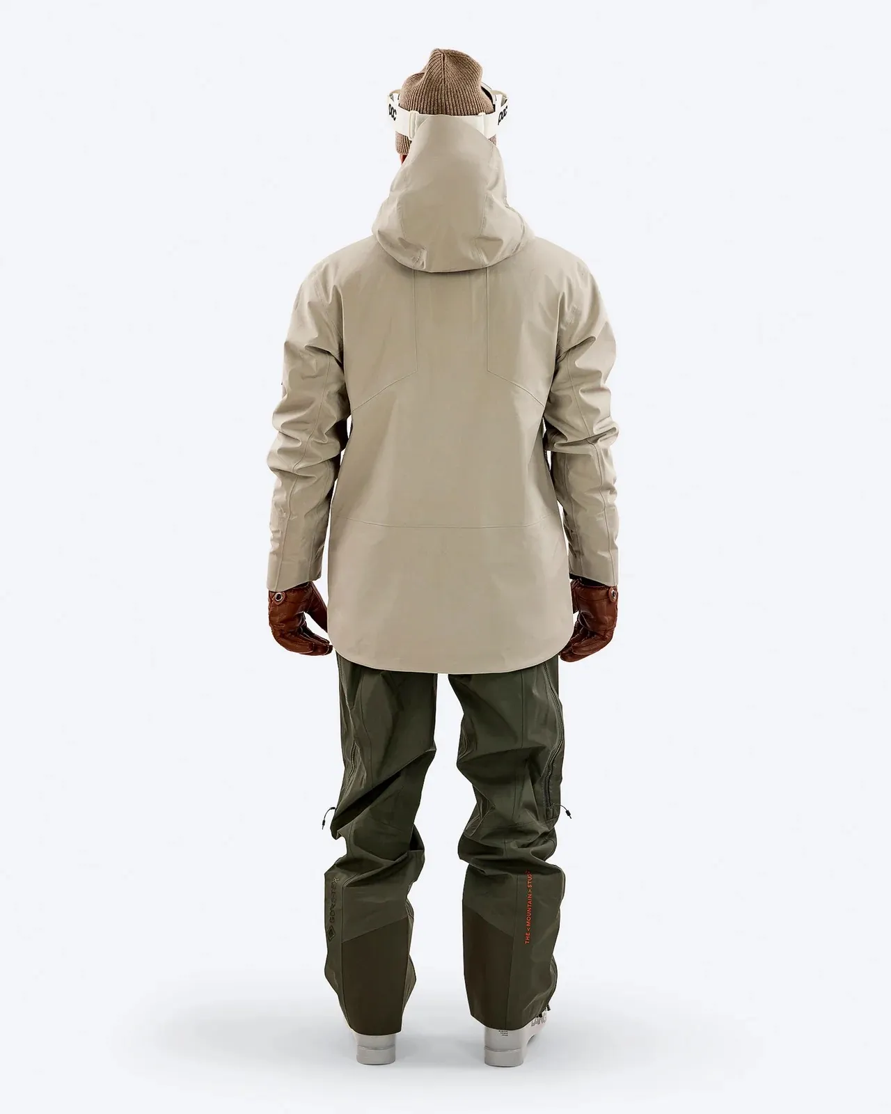 Vista posteriore: giacca Z-2 EPE beige e pantaloni verdi, parte di un completo da sci con berretto e occhiali da sci.