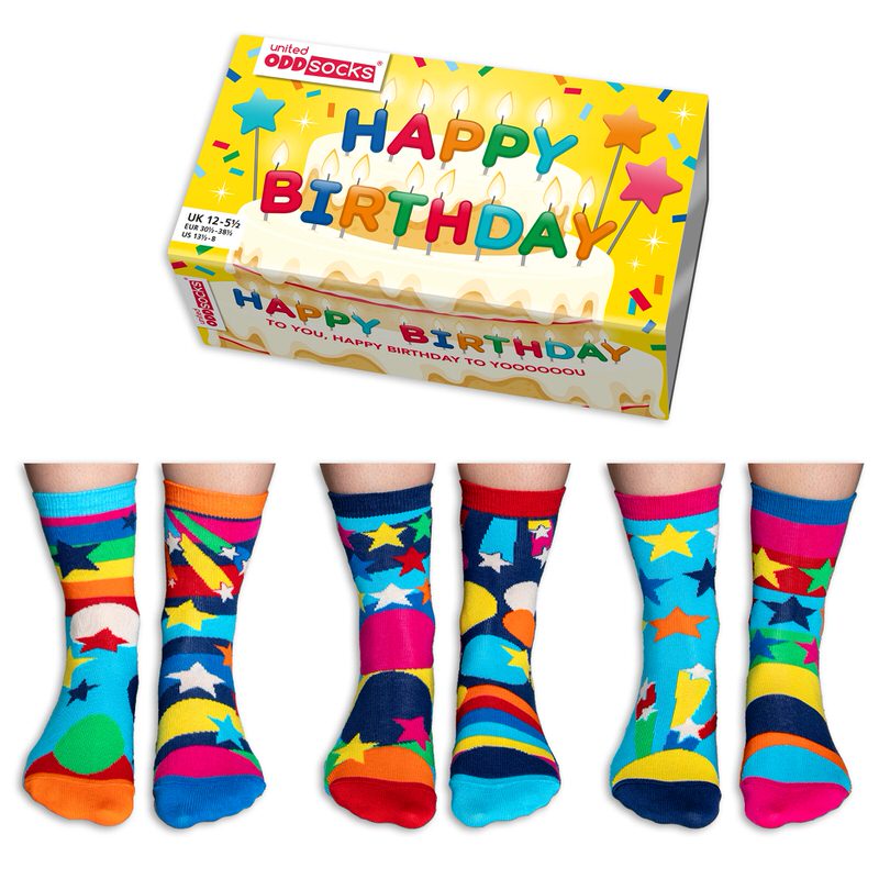 Scatola con la scritta "Happy Birthday" sopra sei piedi di calzini colorati e fantasia.