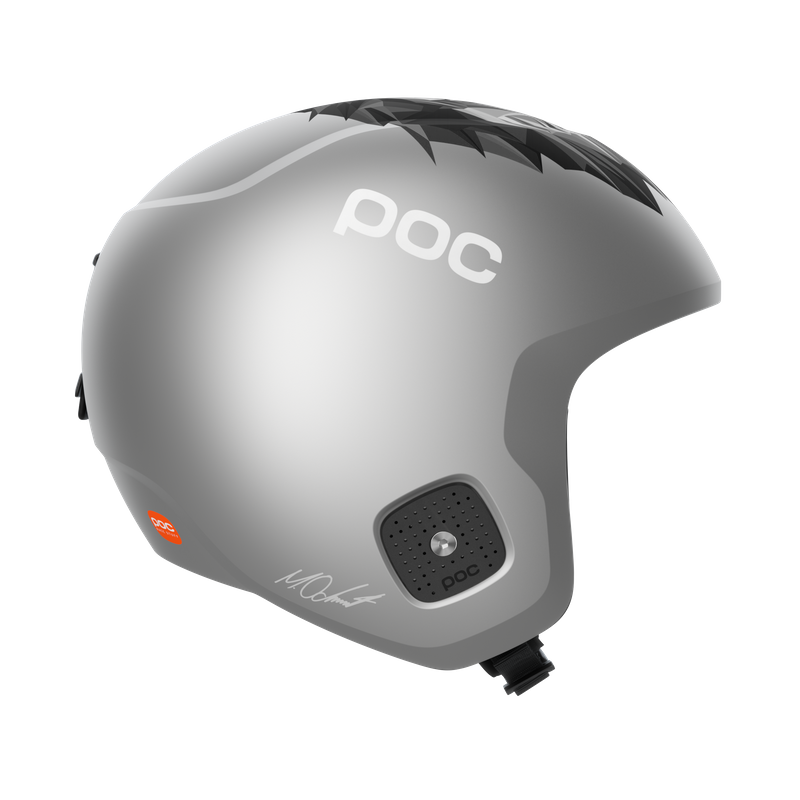 Silberner Skihelm Marco Odermatt Silberner POC Skull Dura Junior Skihelm, seitliche Ansicht, mit Lwendesign oben und Marco Odermatt Signatur.