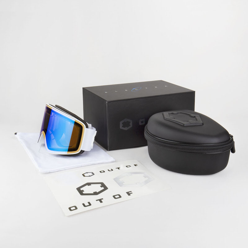 Occhiali da sci Out Of Electra White con lenti blu specchiate, custodia rigida, confezione e accessori su sfondo bianco.