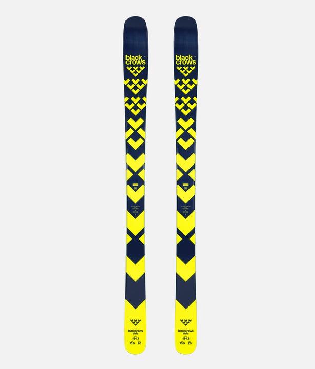 Black Crows Atris skis Two Black Crows Atris skis with a yellow and black arrow design stand parallel in front of a light background.