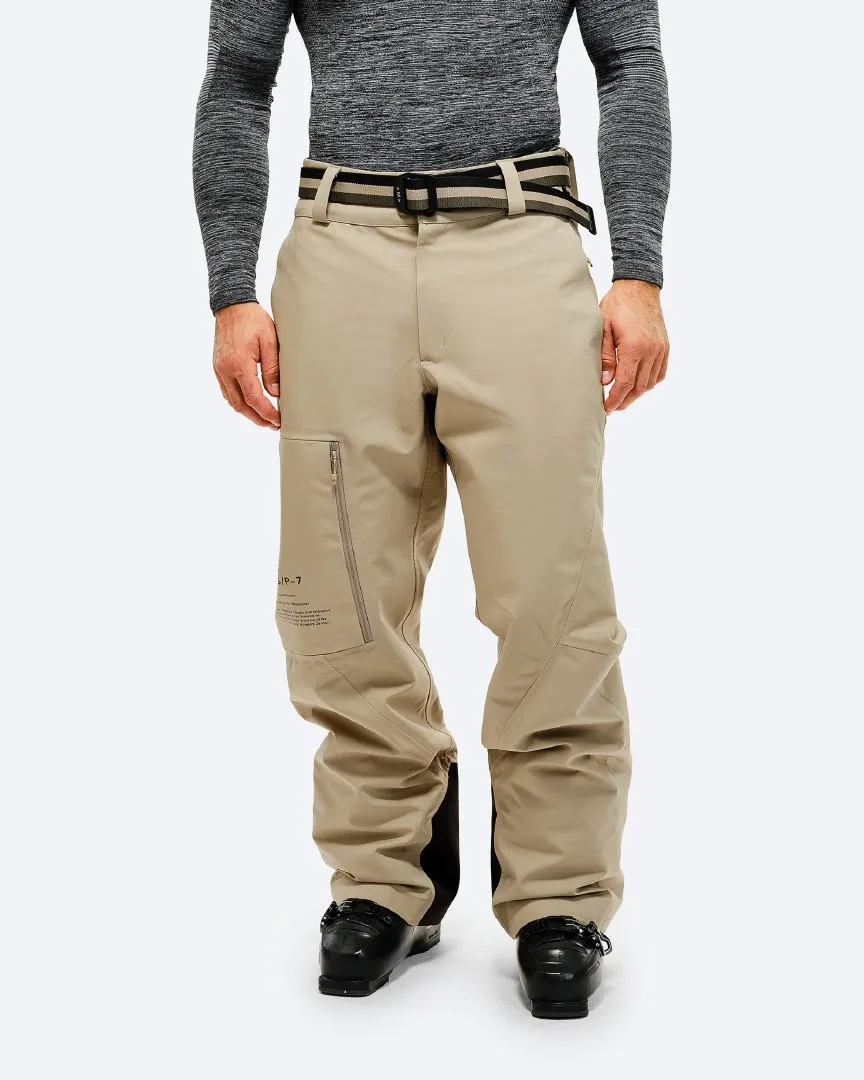 Person wearing a P-7 Ride Insulated Pant in Seneca Rock, with ski boots against a white background.