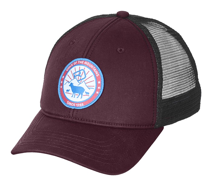 Weinrote Trucker Cap mit schwarzem Mesh-Einsatz und rundem Aufnäher mit Bergszene und Schaf.