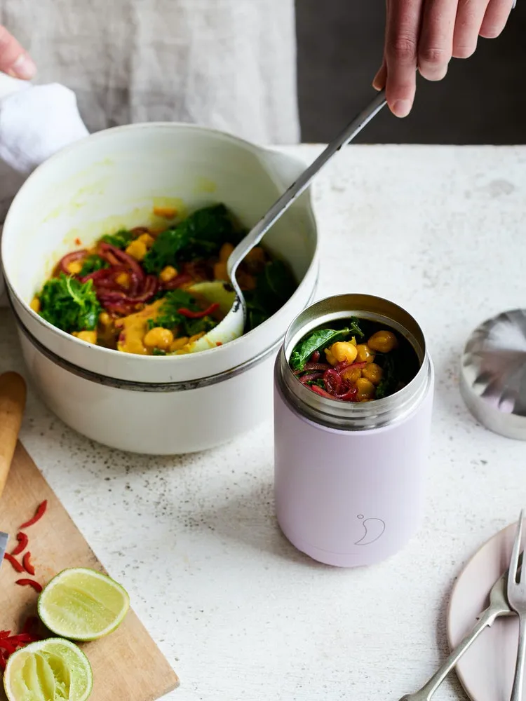 Un Chillys Food Pot grigio chiaro è riempito di curry, insieme a ingredienti come lime e peperoncino.