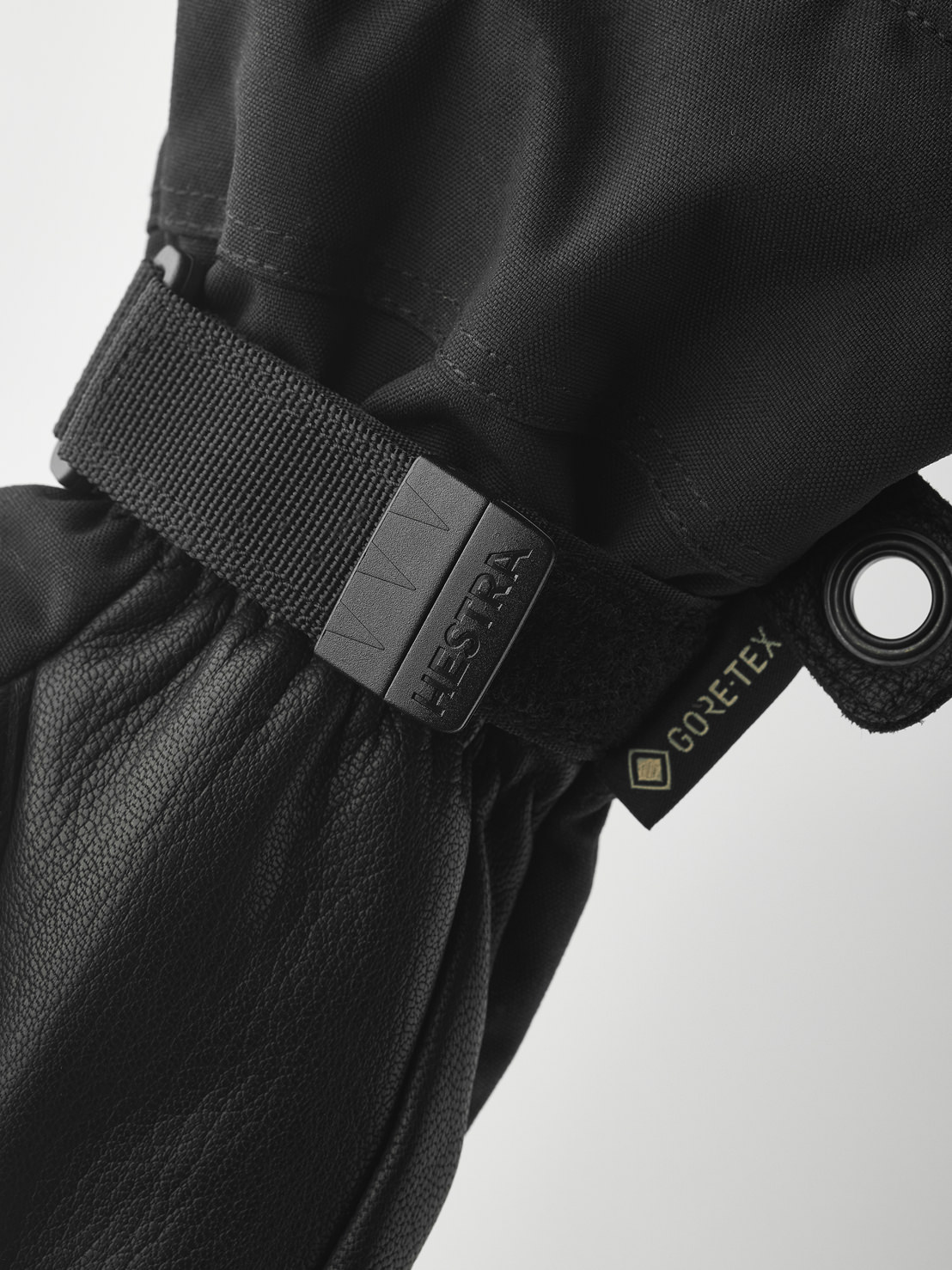 Black Hestra gloves Close-up of a black Hestra glove with Gore-Tex label and adjustable strap. The material is leather and textile.