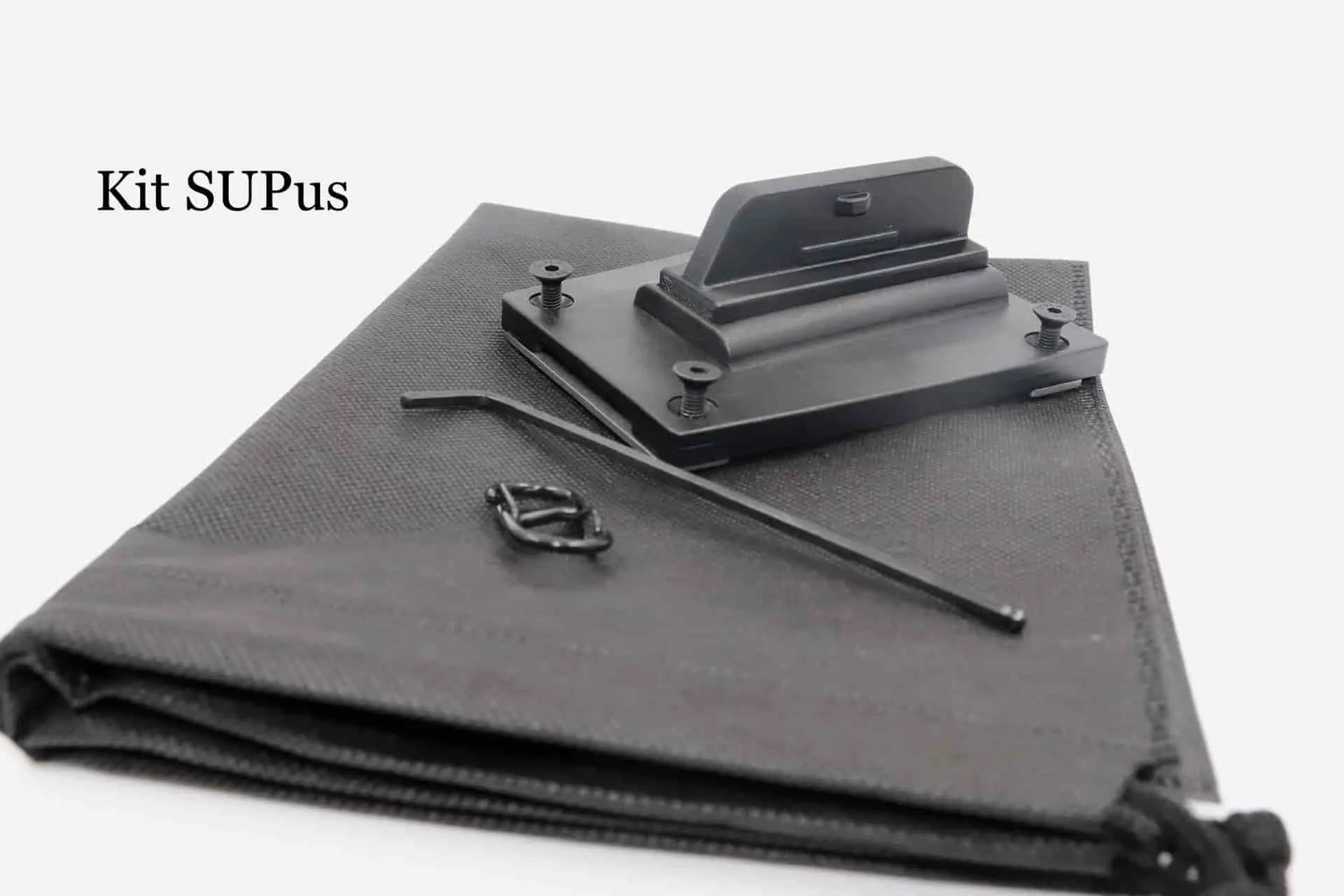 Kit SUPmover SUPdual: piastra di base, attacchi per pinne, borsa in tessuto, chiave a brugola e cinghia in velcro sulla borsa in tessuto scuro.