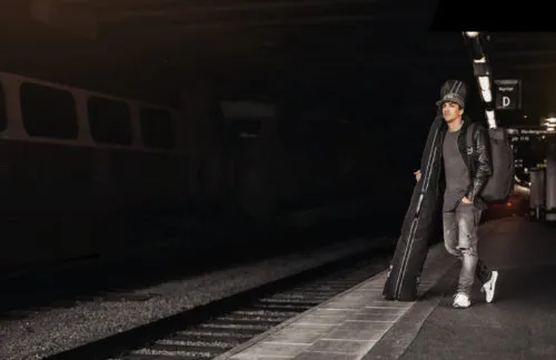 Man on platform with Douchebags backpack and bag.
