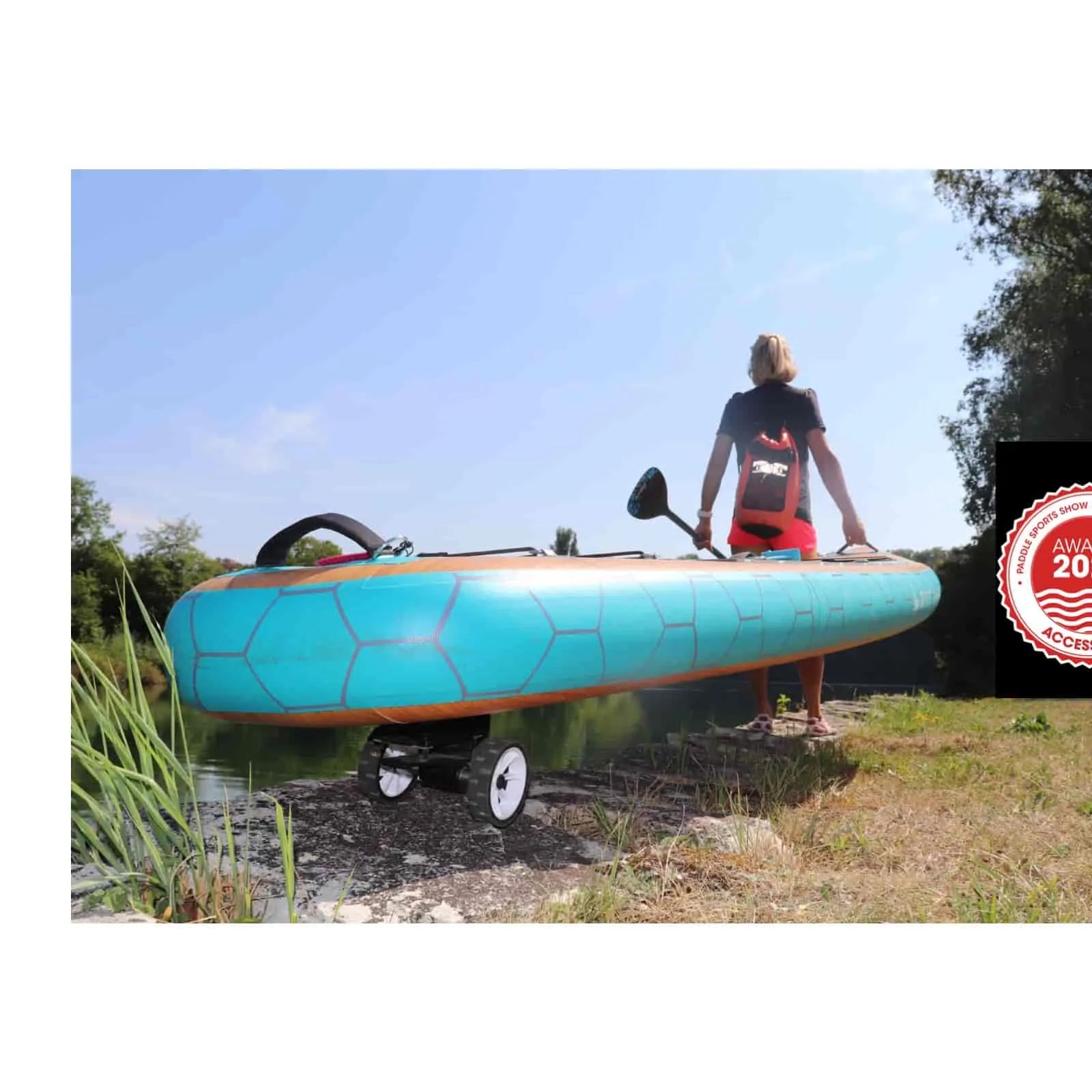 Blue SUP board with SUPmover wheels, carried by person. Paddle is held.