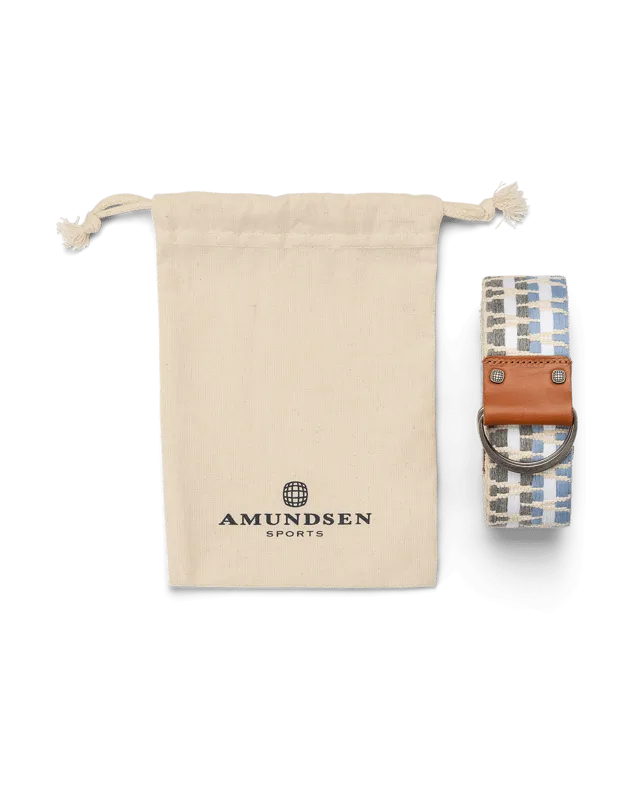 Sac en coton beige avec logo et ceinture à carreaux avec détails en cuir et anneau métallique sur fond blanc.
