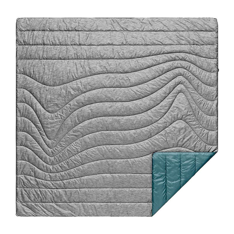 Quadratische, gesteppte Rumpl Puffy Blanket in hellgrau mit wellenförmigem Muster und türkisfarbener Ecke.