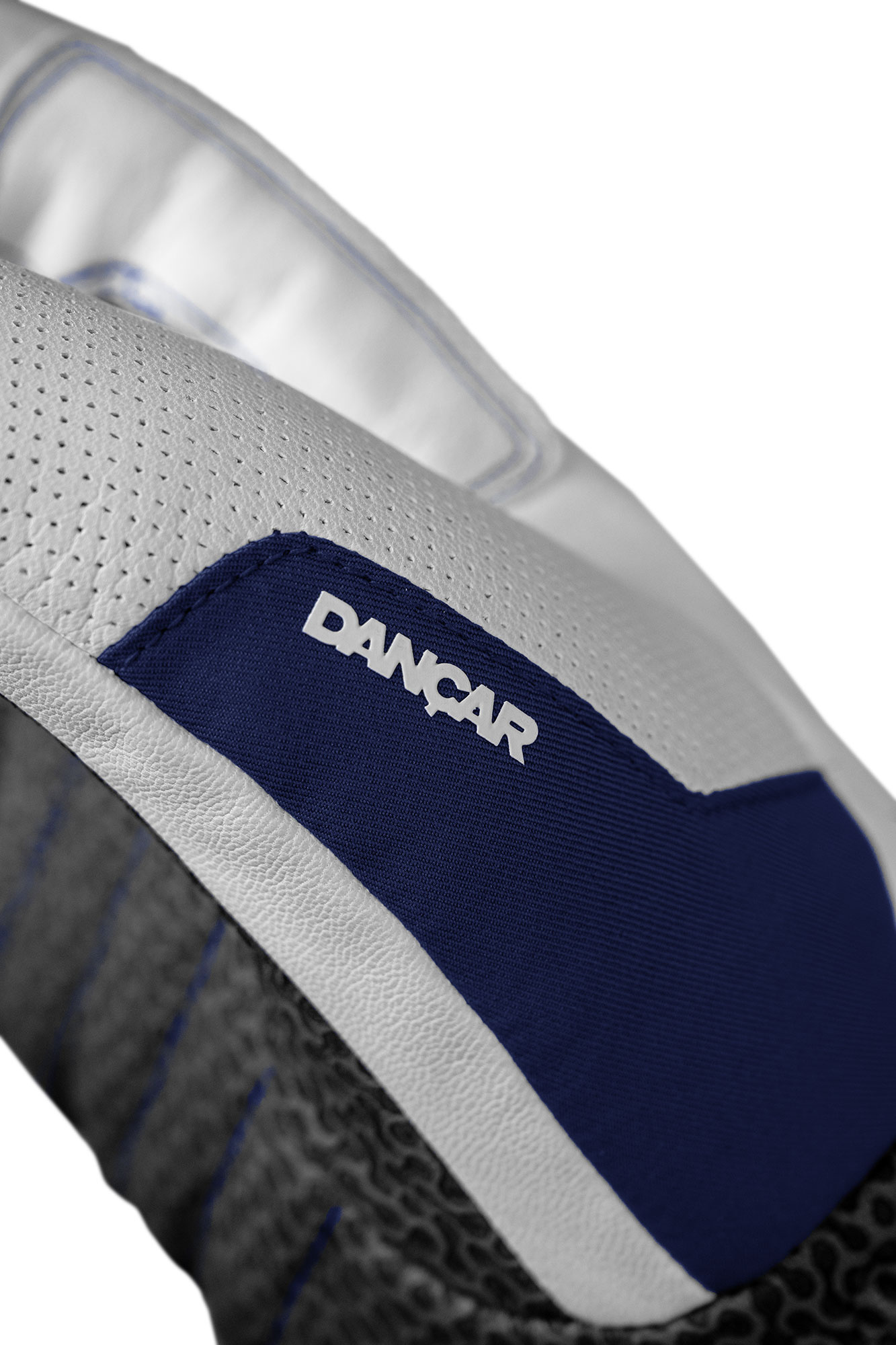 Vue détaillée d'un gant en cuir blanc avec un empiècement en tissu bleu et l'inscription "DANCAR".