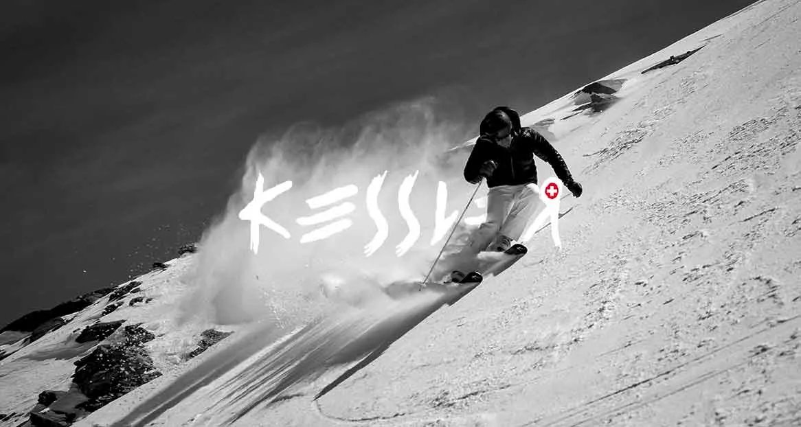 Schwarzweißaufnahme eines Skifahrers in Bewegung auf einer verschneiten Piste, Schnee stäubt hinter ihm auf. Der Schriftzug "Kessler" ist im Bild integriert.