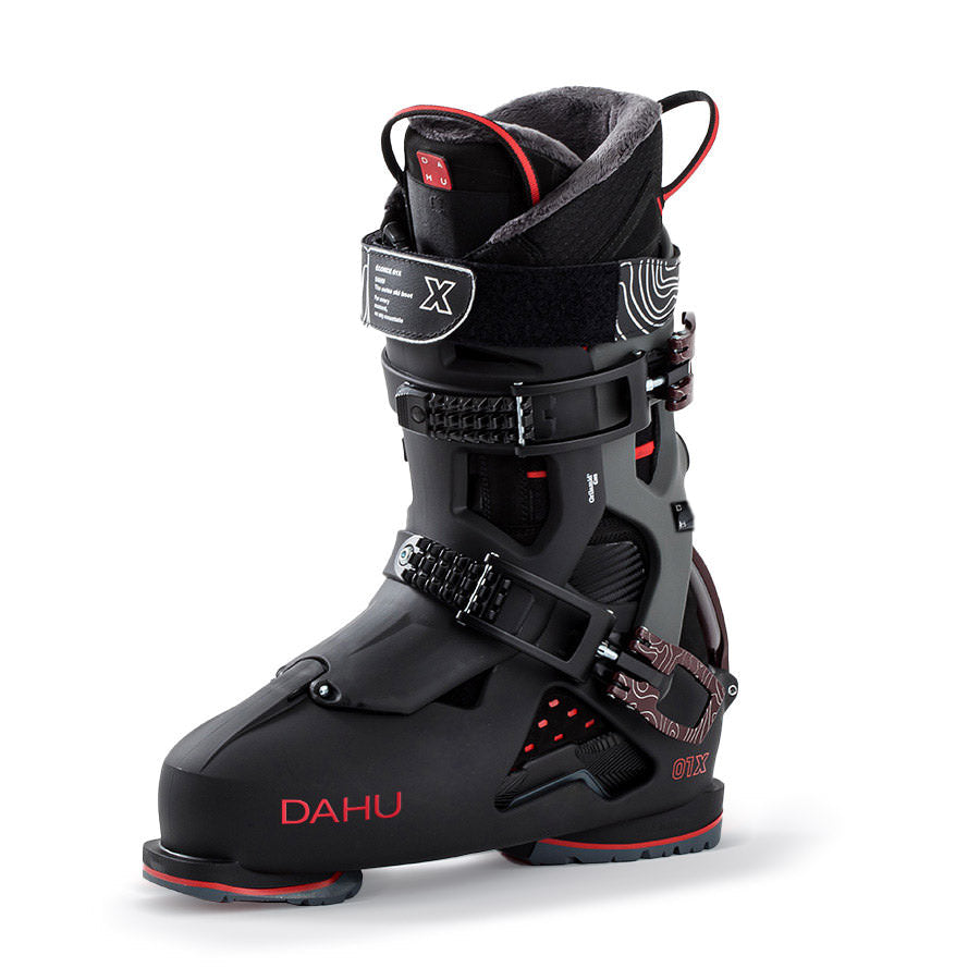 Chaussure de ski noire Dahu Chaussure de ski noire Dahu Ecorce 01X avec des accents rouges, debout sur le côté. Les boucles et la manchette sont visibles.