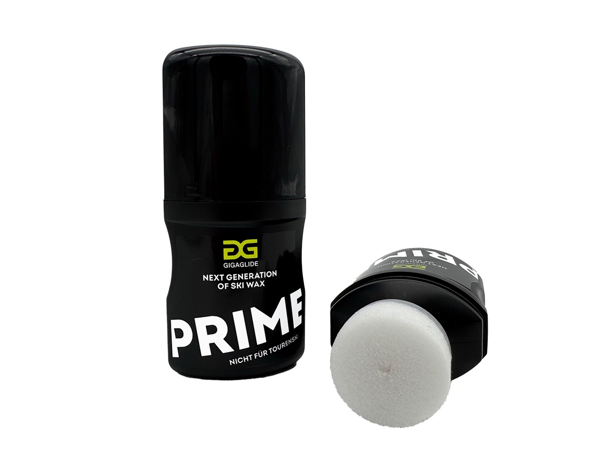 Zwei Behälter schwarzes Skiwachs, einer stehend, der andere liegend mit einem Schwammaufträger.