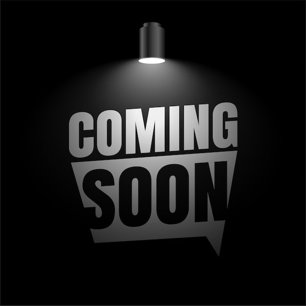 "Coming Soon" Schriftzug unter einem Scheinwerfer in dunklem Raum.