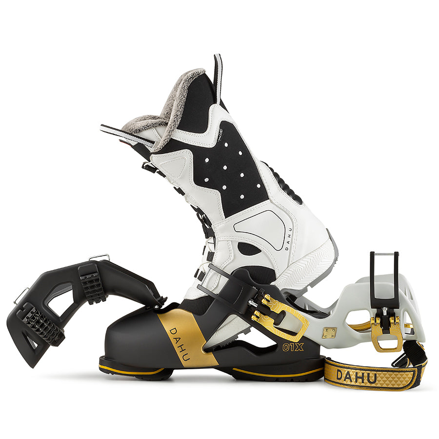 Dahu Ecorce Skischuh Dahu Ecorce 01X Skischuh in Weiss, Schwarz und Gold mit Zubehör seitlich auf weissem Grund.