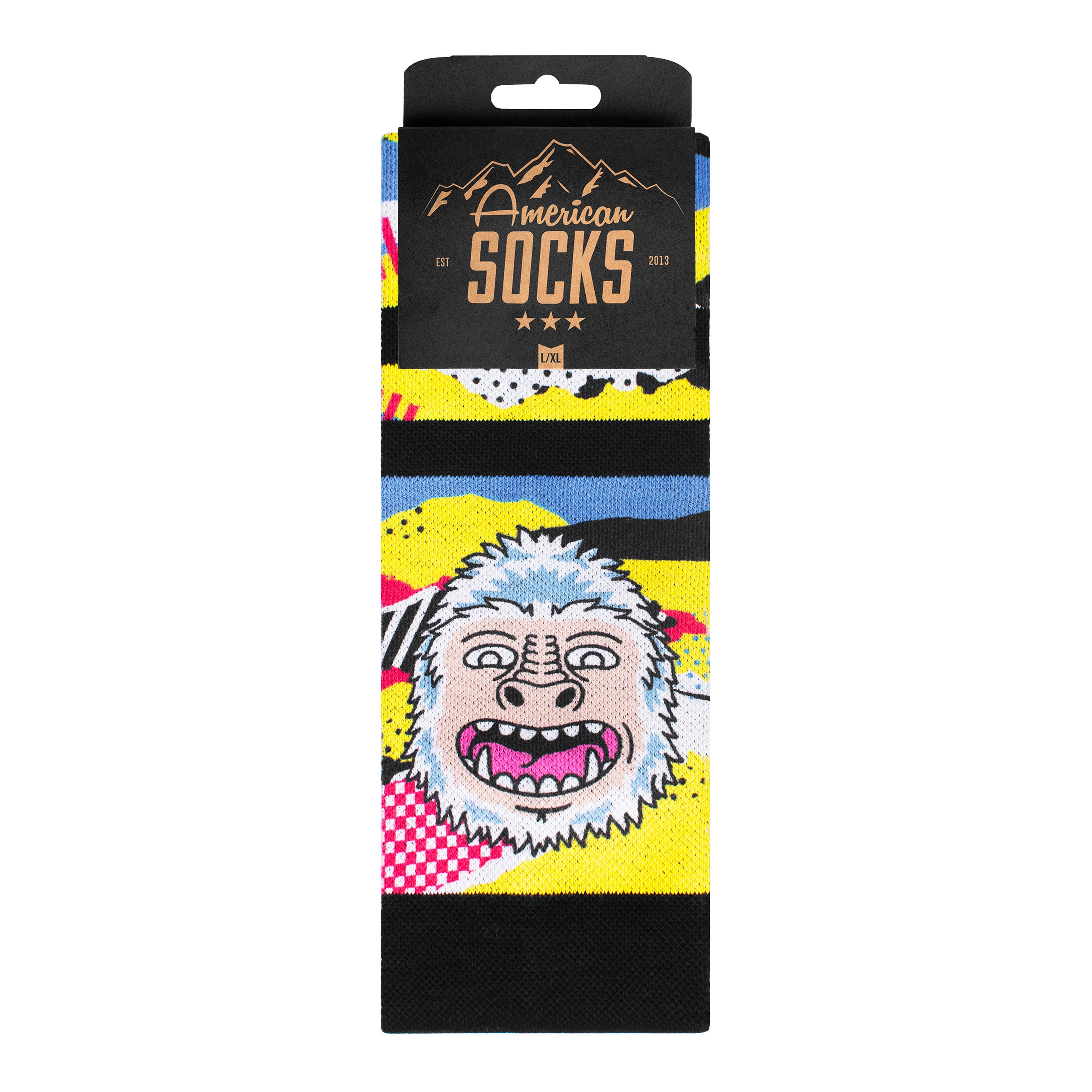 Verpackung der Yeti Snow Socks mit Comic-Yeti-Motiv auf farbenfrohem, gestreiftem Hintergrund.