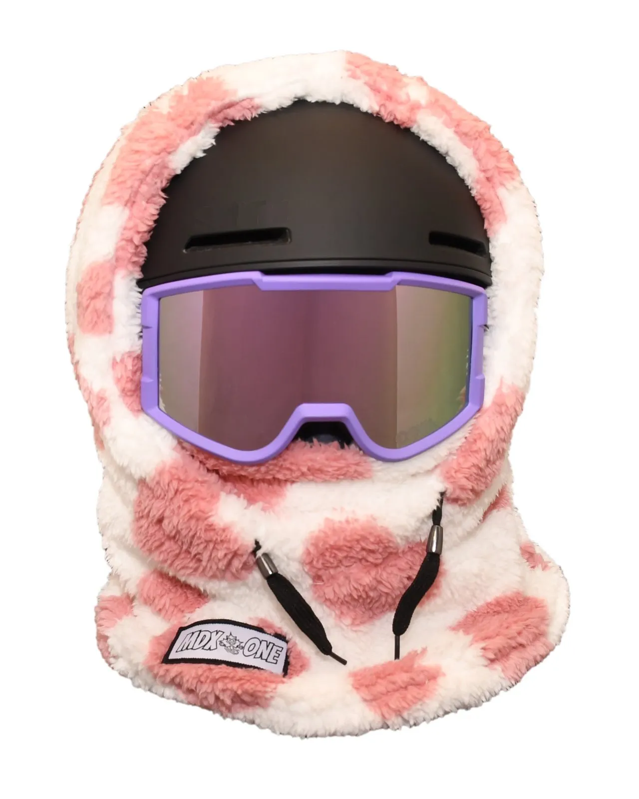 Kuschelige Kinder-Sturmhaube aus weichem Plüsch in Weiß und Rosa mit unregelmäßigen Herzmustern, getragen über schwarzem Skihelm und Skibrille mit violettem Rahmen und verspiegelten Gläsern. Bedeckt Kopf, Hals und unteren Teil des Gesichts.