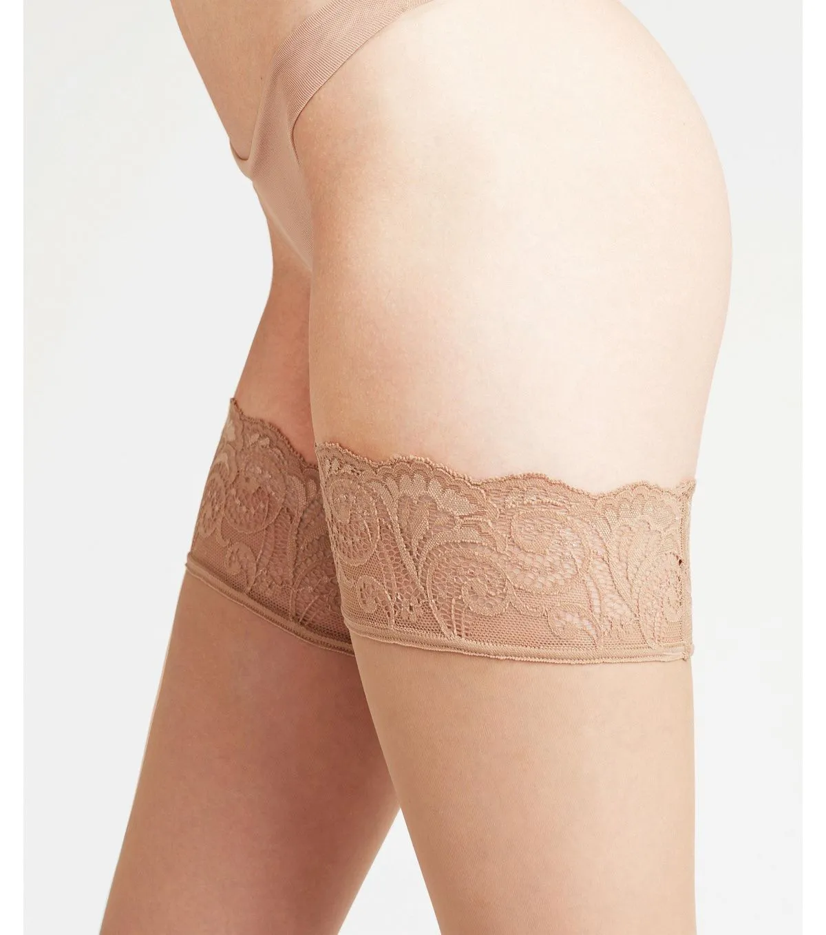Gros plan sur des jambes en stay ups avec dentelle décorative dans la teinte Powder.