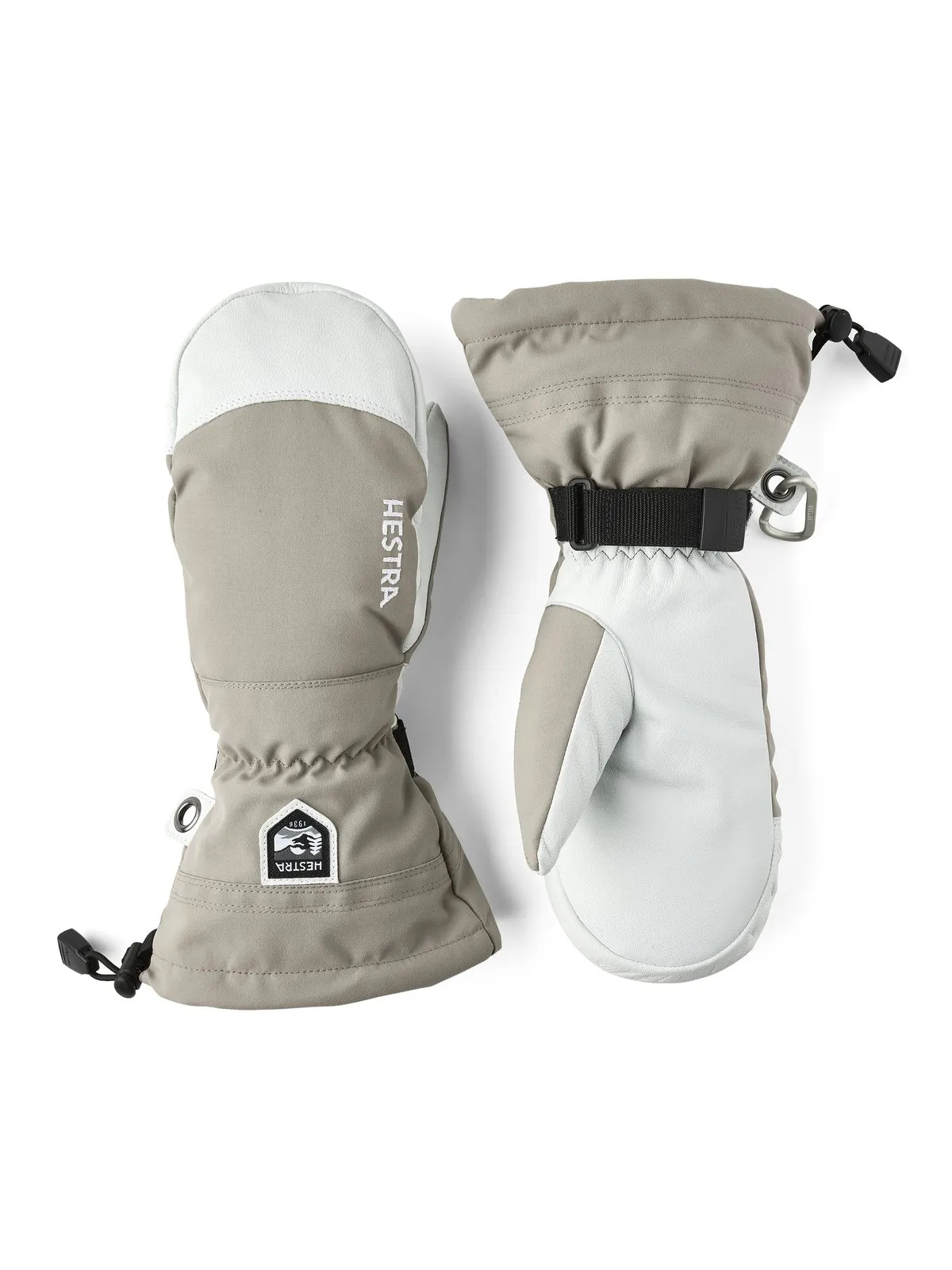 Zwei Hestra Army Leather Heli Ski Fäustlinge, beige und weiß, nebeneinander auf weißem Grund.