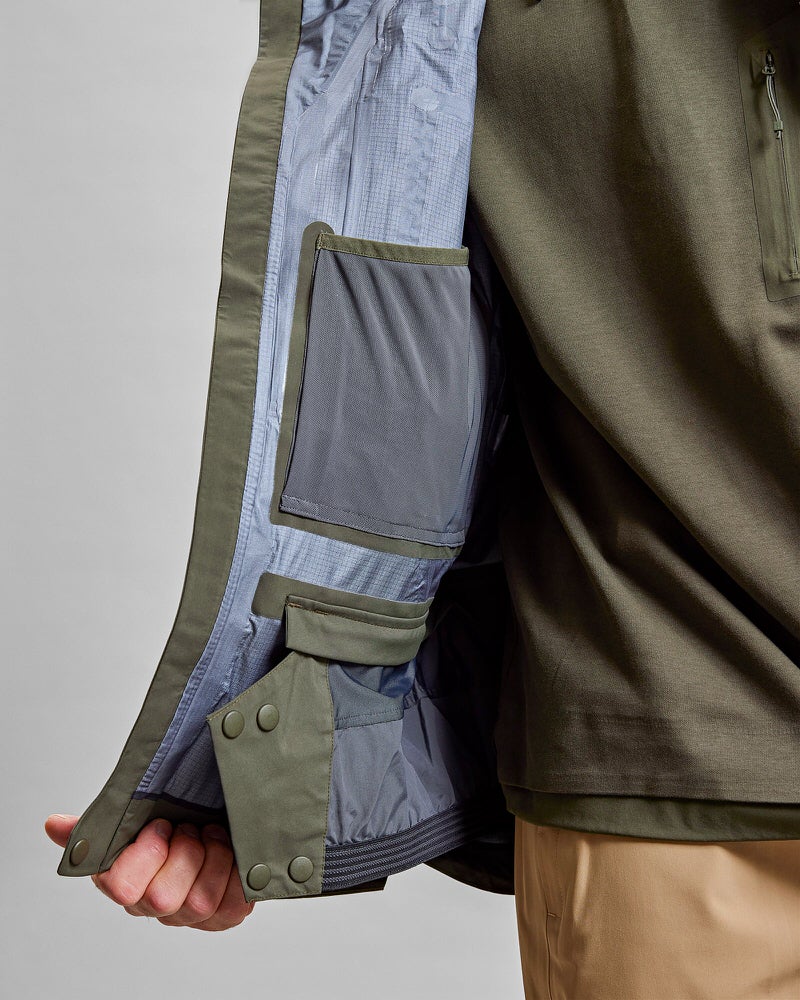 Grüne GORE-TEX Pro Jacke Detailaufnahme: Innenseite einer grünen Z-2 HD GORE-TEX Pro 3L Shell Jacket mit Taschen.