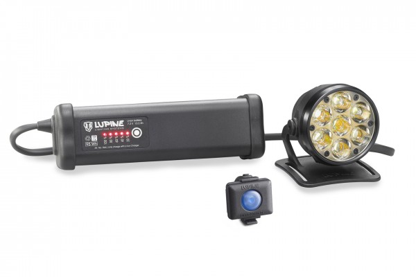 Schwarze Betty R 14 Helmlampe mit Akku, Fernbedienung und Helmhalter auf weißem Hintergrund.