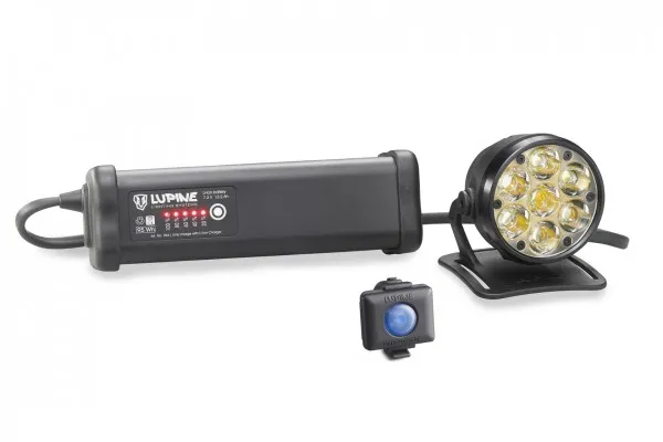 Lampe de casque Betty R 14 noire avec batterie, télécommande et support de casque sur fond blanc.