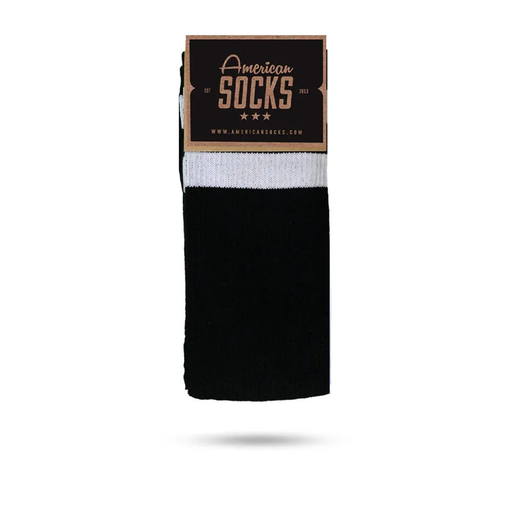 Classic, medium-high, black socks with a white cuff and logo label.