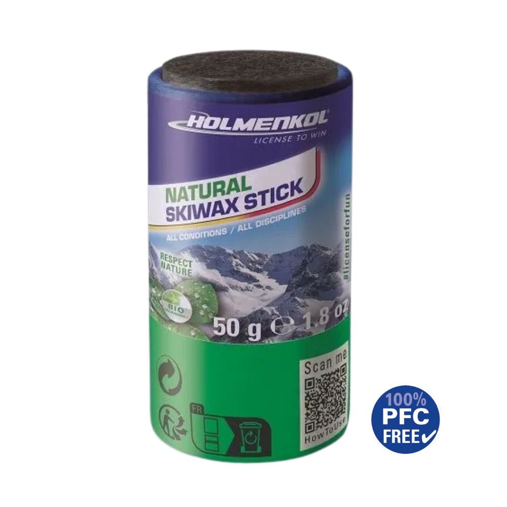 Eine Dose Holmenkol Natural Skiwax Stick, blau-grün mit Bild von verschneiten Bergen und dem Text "Natural Skiwax Stick".