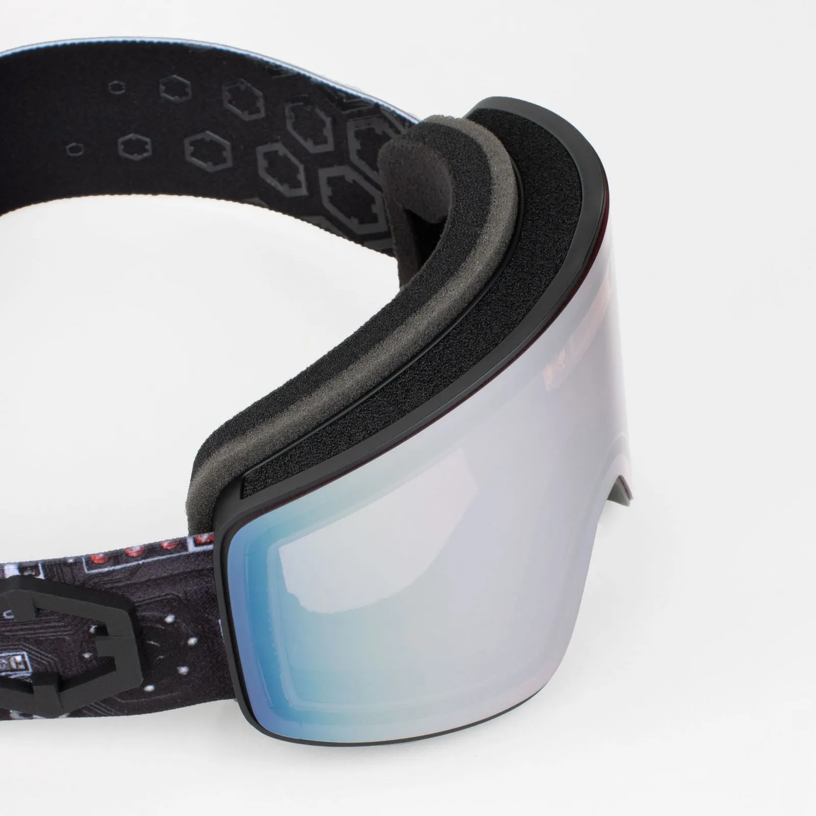 Nahaufnahme der Out Of Electra Motherboar Skibrille mit silberner Linse und schwarzem Band auf weißem Grund.