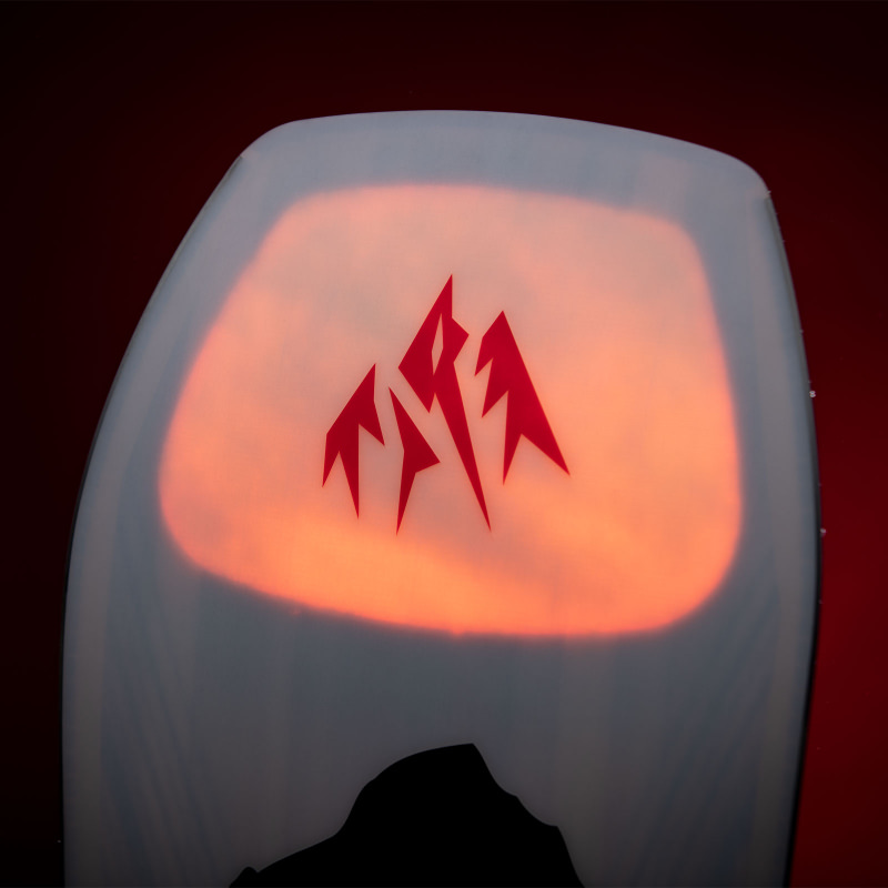 Detailansicht der Nose des Jones Aviator 2.0 LTD Snowboards mit rotem Logo vor Sonnenuntergangs-Grafik.