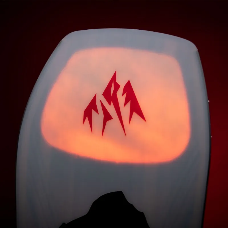 Detailansicht der Nose des Jones Aviator 2.0 LTD Snowboards mit rotem Logo vor Sonnenuntergangs-Grafik.