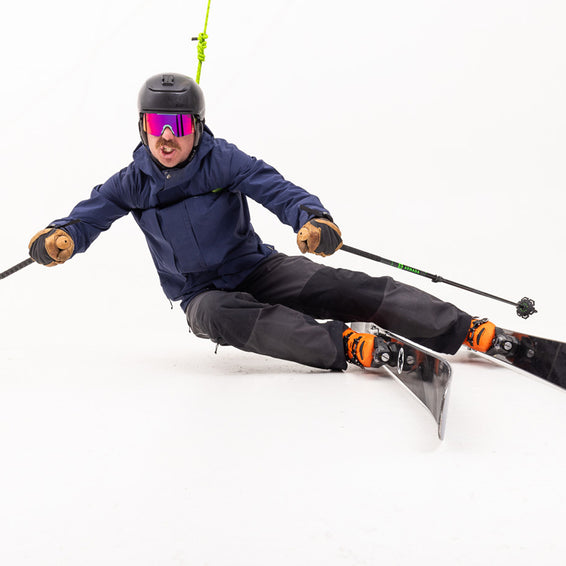 Skifahrer mit pink-lila "The Shabooms Synthesizer" Sonnenbrille beim Skifahren.