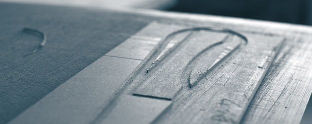 Gefräste Metallplatte Nahaufnahme einer gefrästen Metallplatte mit eingefrästen Formen und Linien.