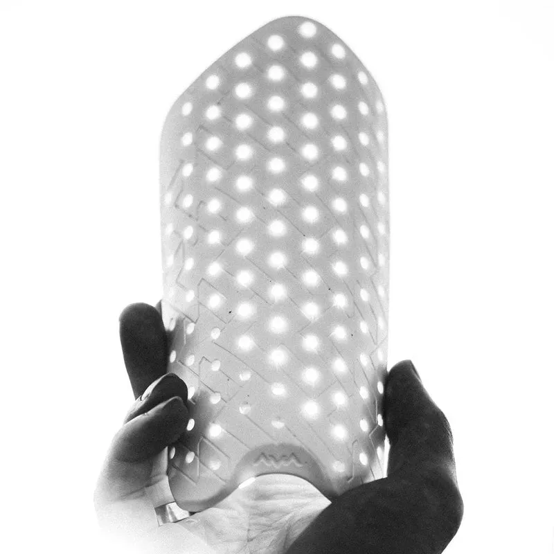 Una mano tiene un parastinchi Flaxta Aircon con fori di ventilazione.
