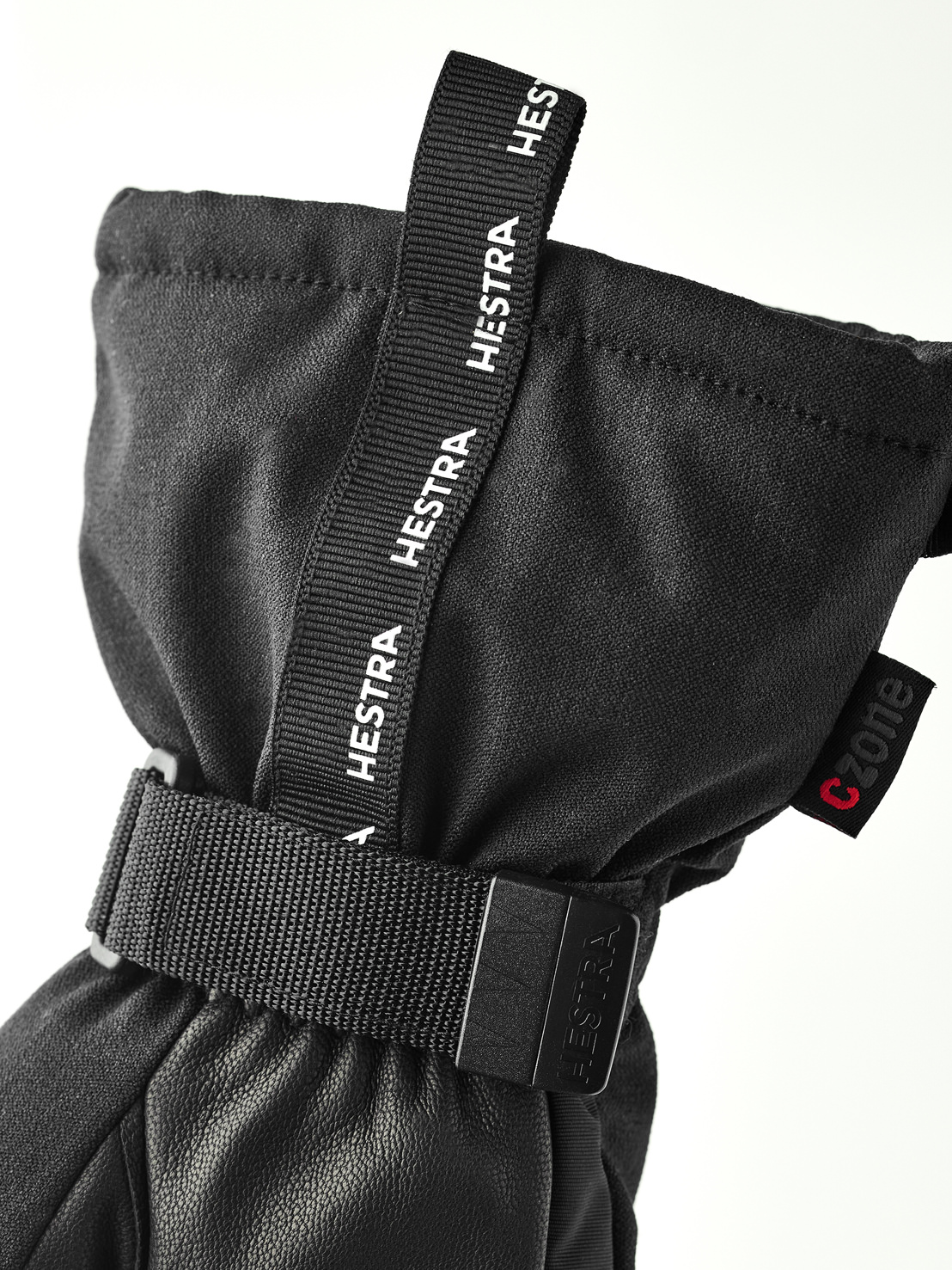Hestra Gant noir Gros plan sur un gant noir Hestra avec dragonne en tissu et sangle de poignet. Le logo CZone est visible.