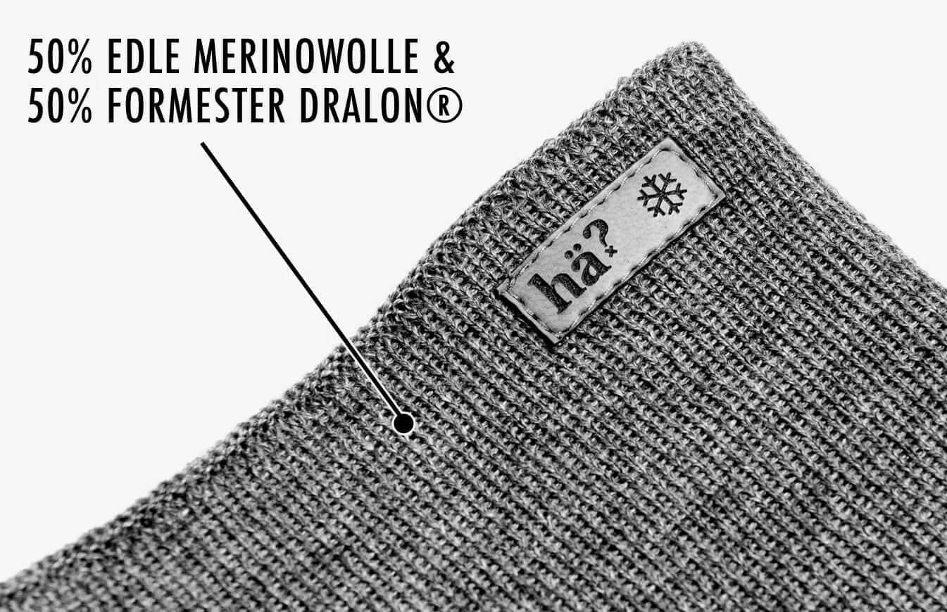 Close-up of the gray Drifter Merino Neckwarmer, knitted pattern, label with lettering and snowflake, material composition.