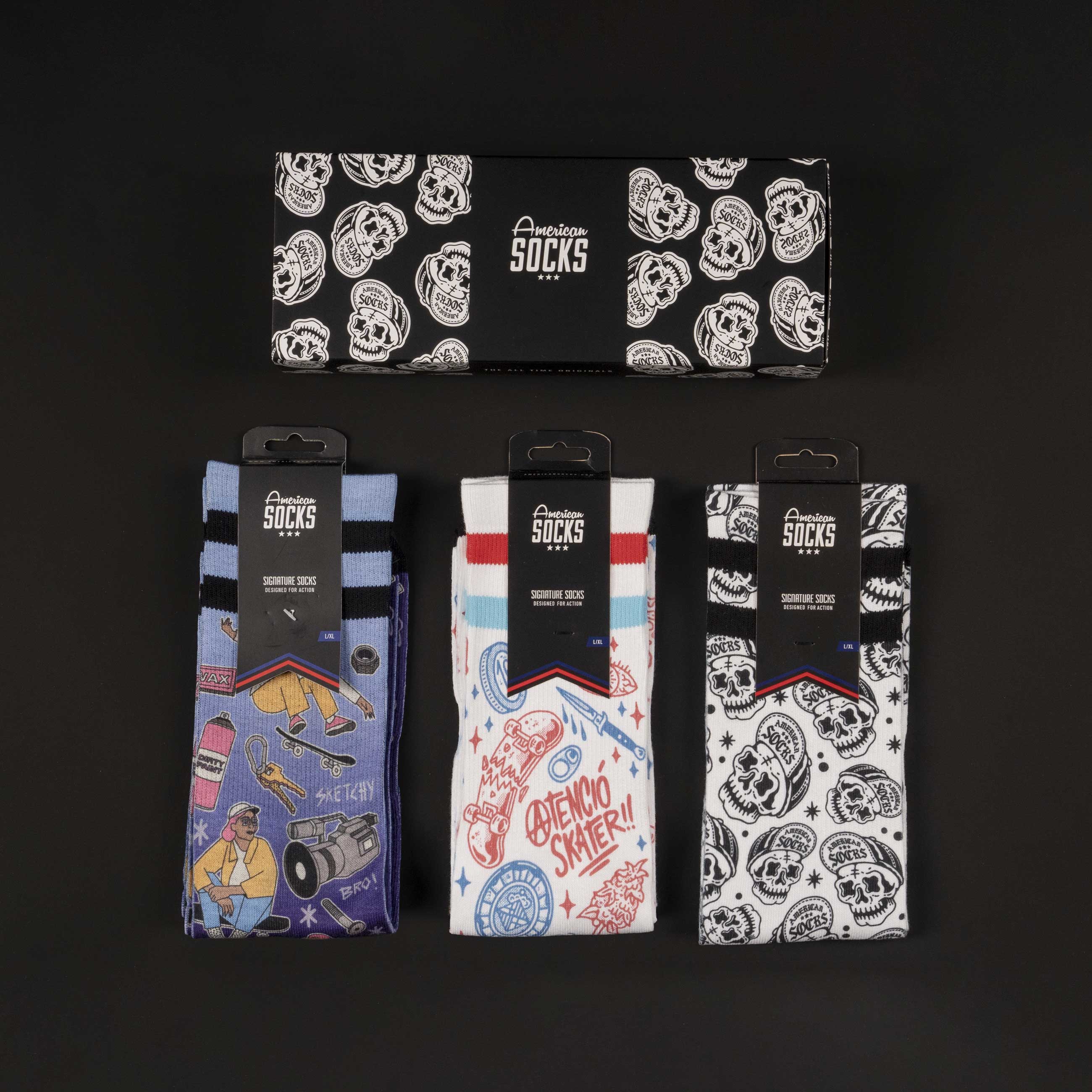 Skater Socken Set Drei Paar American Skater Socks mit Motiv, verpackt in Geschenkbox, auf schwarzem Grund.