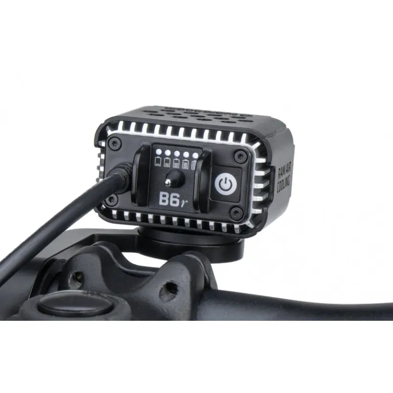 Close-up: Suprabeam B6r 4200lm bike light attached to the handlebars. Controls and cooling fins are visible.