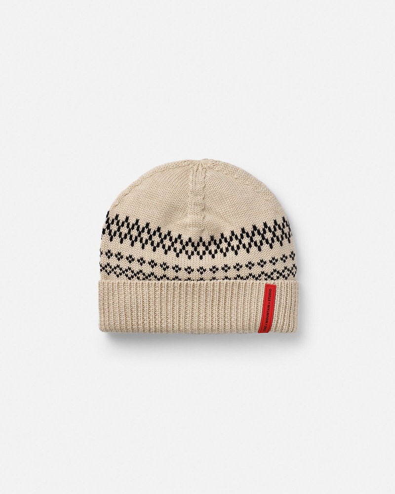Beige wool beanie with black jacquard pattern and red logo label.